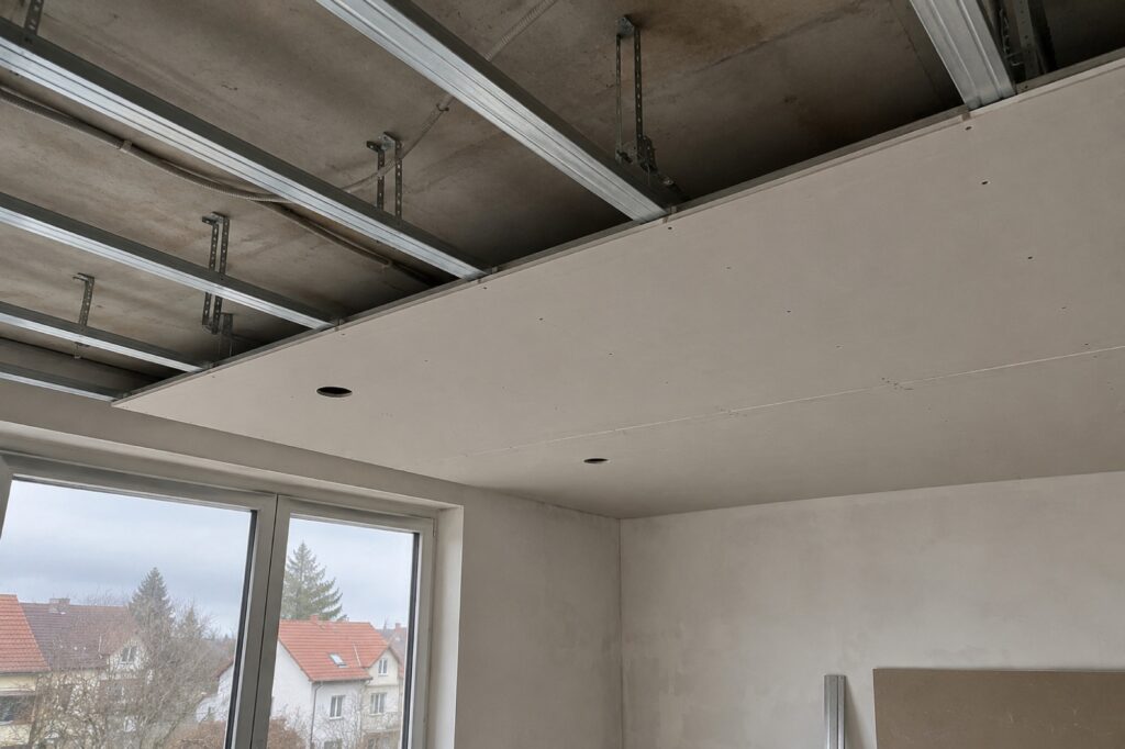 Abgehängte Decke im Bau mit Profilen und ersten Platten